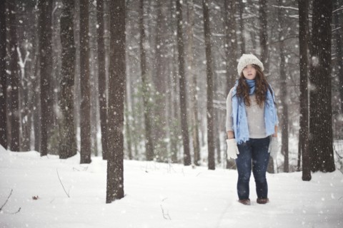 Girl standing in snowy forest
