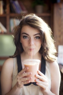 Caucasian teenage girl drinking smoothie in cafe