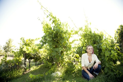Caucasian farmer crouching in rural vineyard