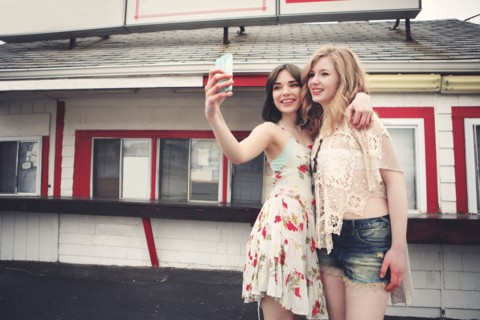 Caucasian friends taking selfie with cell phone