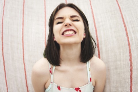 Caucasian woman grinning with bared teeth