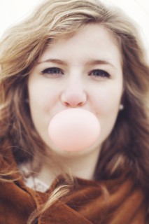 Caucasian teenage girl blowing bubble gum bubble