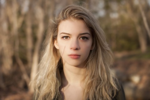 Caucasian teenage girl standing in park