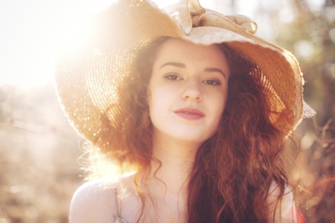 Hispanic woman wearing sun hat outdoors