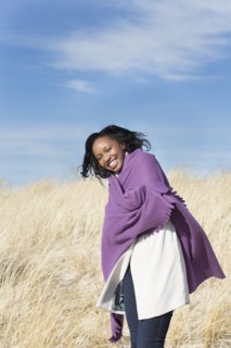Woman wrapped in shawl on beach