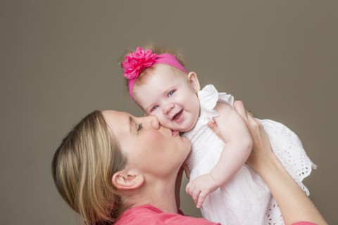 Close up of mother kissing baby girl