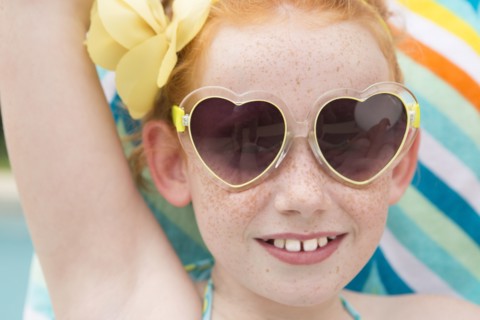 Close up of Caucasian girl wearing heart-shaped sunglasses