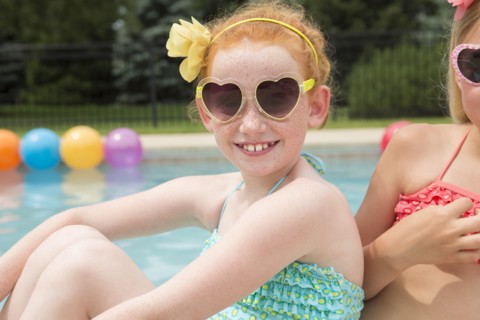 Caucasian girls smiling near swimming pool