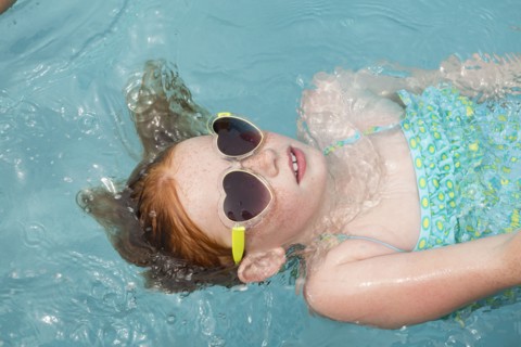 Caucasian girl floating in swimming pool