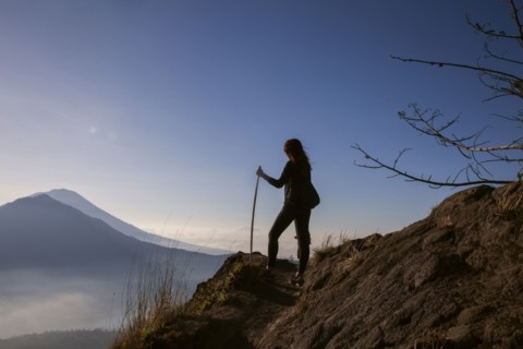 Woman admiring rural landscape from mountain path