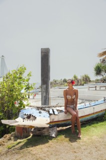 Woman sitting on traditional canoe