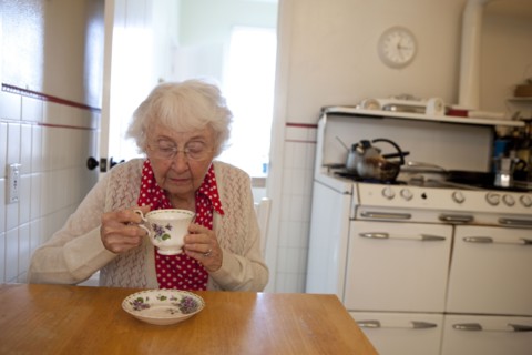 Older woman drinking tea in kitchen