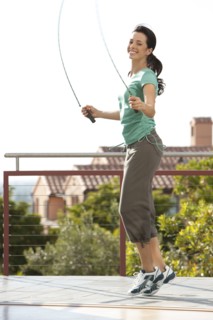 Caucasian woman jumping rope on urban rooftop