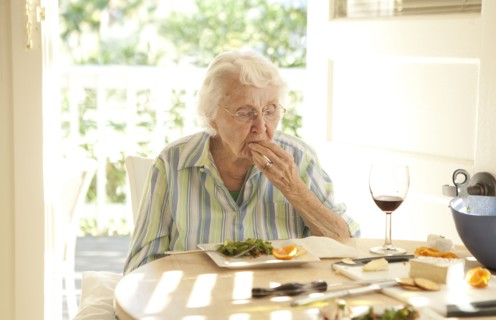 Older Caucasian woman eating lunch at table