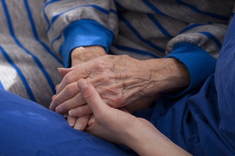 Close up of granddaughter holding hands of grandmother