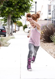 Smiling girl running on city sidewalk