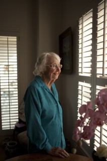 Smiling older Caucasian woman looking out window