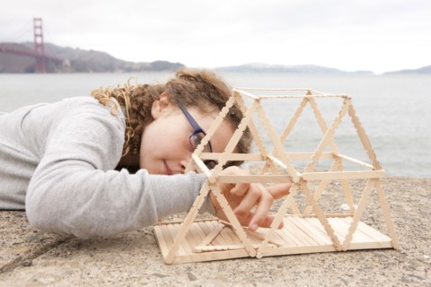 Caucasian girl examining project on wall over ocean