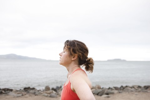 Caucasian woman resting on rocky beach