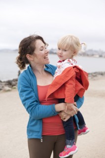 Caucasian mother holding daughter on beach