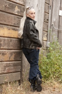 Older Caucasian woman leaning on wooden wall