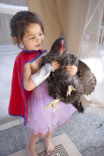 Mixed race girl holding chicken