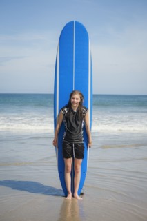 Caucasian girl holding paddleboard on beach