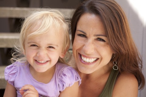 Caucasian mother and daughter smiling on steps