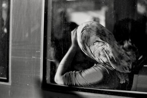 Woman in headscarf riding in train