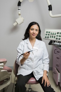 Indian dentist holding tool in office