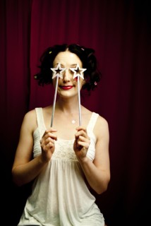 Glamorous woman holding stars over eyes