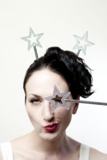 Glamorous winking woman holding star over eye
