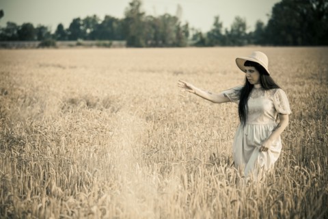 Woman walking in tall grass in rural field