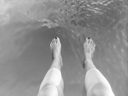 High angle view of legs of woman dangling in lake