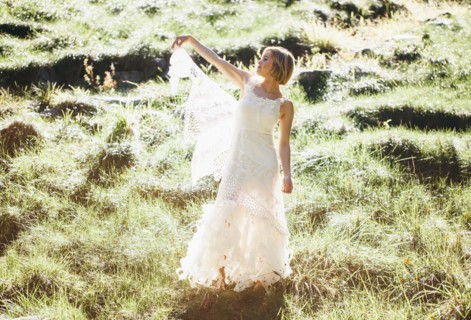 Bride wearing wedding gown in rural field