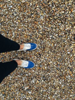Caucasian woman wearing sneakers in pebbles