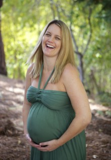 Laughing pregnant woman holding belly