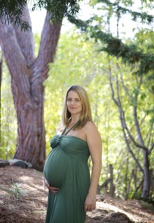 Smiling pregnant woman holding belly
