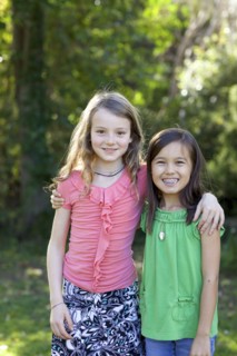 Smiling girls hugging in backyard