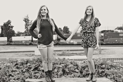 Teenage girls holding hands in train yard