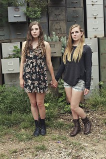 Women holding hands near dilapidated office drawers in garden