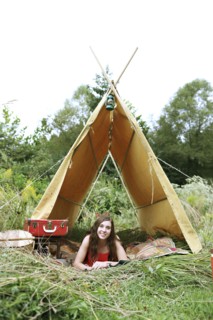 Woman laying in camping tent in field