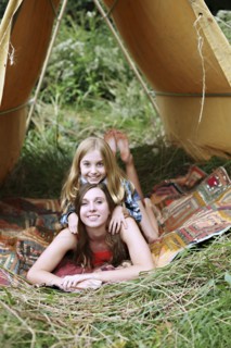 Sisters laying in camping tent