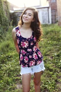 Smiling teenage girl standing in overgrown garden