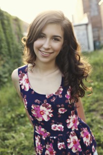 Smiling teenage girl standing in overgrown garden