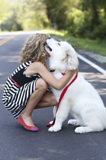 Close up of girl hugging dog on road