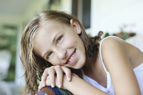 Close up of smiling girl leaning in armchair