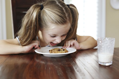 Girl shouting at cookie on table