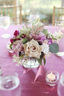Bouquet of flowers in vase on pink tablecloth