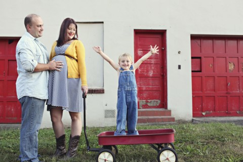 Parents watching son cheering in toy wagon
